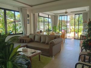 a living room with a couch and a table at Celine Pool Villa Cha-Am in Cha Am