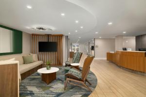 a hotel lobby with a couch and a table at SpringHill Suites Boca Raton in Boca Raton
