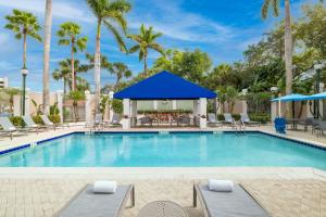 a swimming pool with chairs and a gazebo at SpringHill Suites Boca Raton in Boca Raton