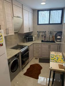 a kitchen with a washer and a sink and a stove at Salam Apartments in Amman