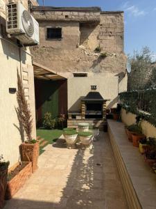a courtyard of a house with plants and a fireplace at Salam Apartments in Amman