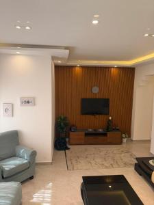 a living room with a couch and a flat screen tv at Salam Apartments in Amman