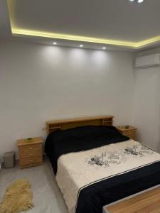 a bedroom with a bed and two night stands at Salam Apartments in Amman