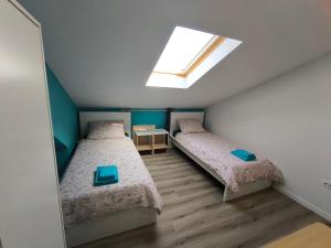 two beds in a small room with a skylight at Apartment Juliet in Izola