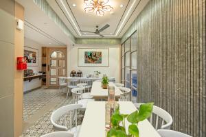 a restaurant with white tables and white chairs at Treebo Arizona in Gandhinagar