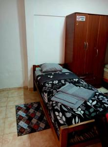 a small bed in a room with a cabinet at Departamento J&J 2 in Aristóbulo del Valle