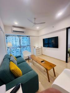 a living room with a green couch and a table at Serene white studio - 2nd floor in Dehu Road
