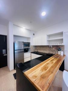 a kitchen with a wooden counter top in a room at Serene white studio - 2nd floor in Dehu Road