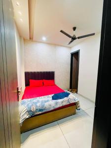 a bedroom with a bed with red pillows and a ceiling at Hotel Dream Stay in Pānīpat