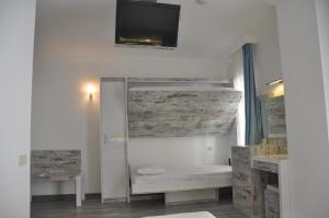 a white bathroom with a tv on the wall at Nur Hotel in Kaş