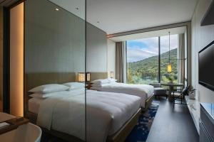 a hotel room with two beds and a large window at Renaissance Taipei Shihlin Hotel in Taipei