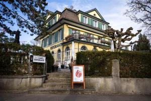 a large yellow house with a sign in front of it at B&B Zoo Caffè & Ristorante in Zurich