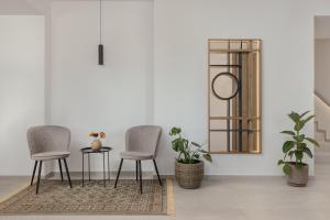 two chairs and a table in a room with plants at Areti Guesthouse in Víssani