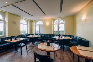 a dining room with tables and chairs and windows at B&B Zoo Caffè & Ristorante in Zurich