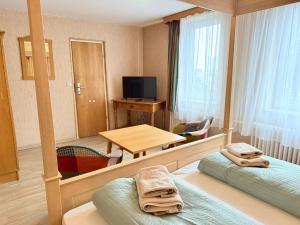 a room with two beds and a table and a mirror at Hotel Zur Erholung in Braunlage