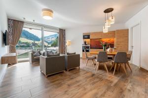 a kitchen and living room with a table and chairs at Adler Resort in Saalbach-Hinterglemm