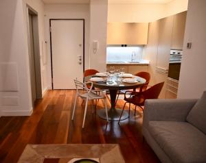a living room with a table and chairs and a kitchen at Brera Elegant in Milan