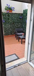 an open door with a patio with a bench and flowers at Residenza Mazzini in Avezzano