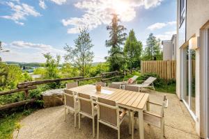 a wooden table and chairs on the patio of a house at Center Parcs Bostalsee Saarland in Nohfelden