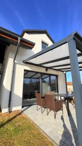 a patio with two chairs and a table at Domki Premium Nad Bałtykiem in Wodnica