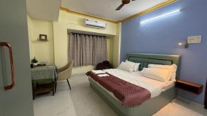 a bedroom with a bed and a table and a desk at Spacious 2BHK flat in new panvel in Navi Mumbai