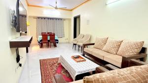 a living room with a couch and a piano at Spacious 2BHK flat in new panvel in Navi Mumbai