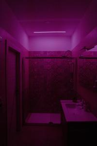 a purple bathroom with a shower and a sink at Villa Enza B&B in Ginosa