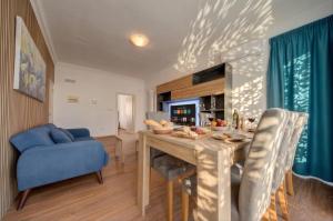 a living room with a table and a blue couch at Sliema Seaview 4BD Apartments & Penthouse with Jacuzzi in Sliema