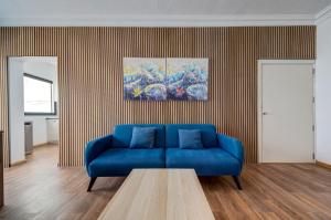 a living room with a blue couch and a table at Sliema Seaview 4BD Apartments & Penthouse with Jacuzzi in Sliema +58 photos