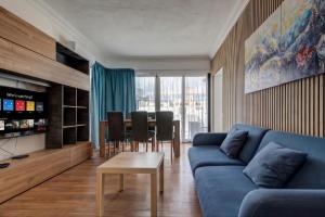 a living room with a blue couch and a table at Sliema Seaview 4BD Apartments & Penthouse with Jacuzzi in Sliema
