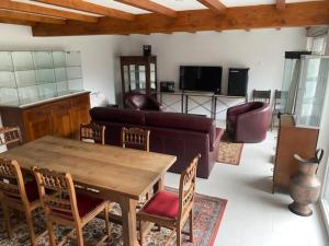 a living room with a couch and a table and chairs at Logement Sierentz proche aéroport in Sierentz