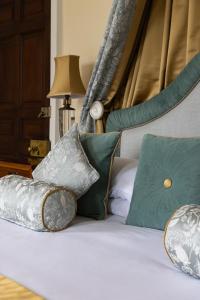 a bed with pillows on top of it at Hintlesham Hall Hotel in Ipswich