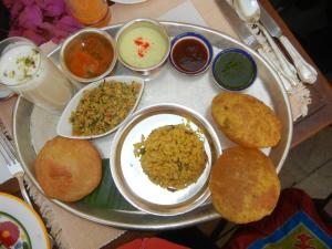 a tray filled with different types of food on a table at Hotel King Plaza in Nikurān