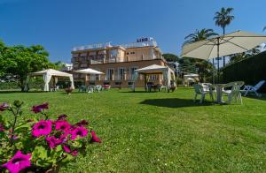 a building with tables and chairs and an umbrella at Hotel Lido in Marina di Massa