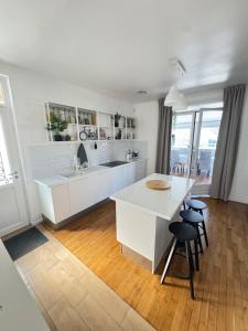 a kitchen with a white counter and a table and chairs at Large house with garden in Vulaines-sur-Seine
