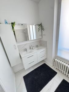 a white bathroom with a sink and a mirror at Large house with garden in Vulaines-sur-Seine +10 photos