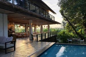 a house with a swimming pool and a patio at JungleNest Resort in General Luna