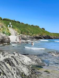 a group of people playing in the water on a beach at Clonakilty Cozy Nest in Clonakilty