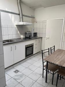 a kitchen with white cabinets and a table with chairs at Deux chambres disponibles pour vous in Aalst +60 photos