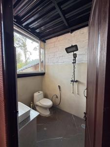 a bathroom with a toilet and a sink and a window at Mad & Nomad Backpackers Hostel in Coonoor +84 photos