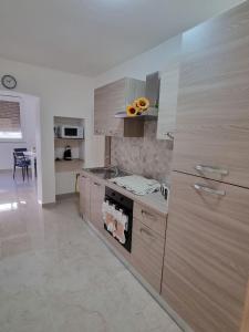a kitchen with wooden cabinets and a stove top oven at ASTRA Guest House in Taranto