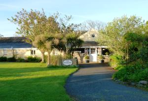 a house with a sign in front of a driveway at The Waterings in St. Davids