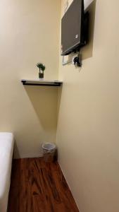 a room with a bed and a tv on the wall at City Hub Hotel Sitiawan in Sitiawan