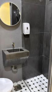 a bathroom with a sink and a mirror and a toilet at City Hub Hotel Sitiawan in Sitiawan