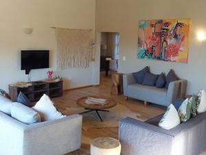a living room with two couches and a tv at Villa Alba in Margate