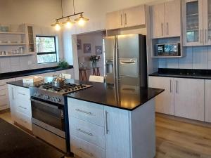 a kitchen with a stainless steel refrigerator and a stove at Villa Alba in Margate
