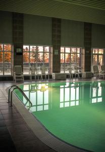 a large swimming pool with chairs in a building at Hotel Hrádok in Jelšava