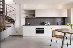 a kitchen with white cabinets and a table and a staircase at Splend'Or - A Real Paradise in Perledo