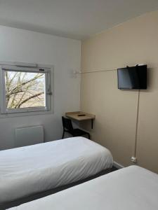 a room with two beds and a desk and a window at Unisotel Bollène A7 Ex-Hotel F1 in Bollène