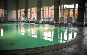 ein großer Pool mit Stühlen in einem Gebäude in der Unterkunft Hotel Hrádok in Jelšava